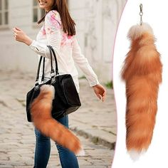 an orange cat tail hanging from a woman's hand with a black purse on it