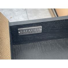 the seat is black and has a silver name plate that reads safavieh avenue