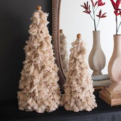 three small christmas trees sitting on top of a mantle