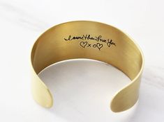 "Actual Handwriting Bracelet / Signature Bracelet / Custom Cuff Bracelet Our custom Handwriting Cuff Bracelet is made from actual hand-writings, drawings, and signatures photographed from cards and documents from the past. All we need is a photo of the writing - phone photos work great! Choose large text, medium text, or mini text along with brass, copper and aluminum metals in a brushed satin finish. Packaged in our Tom Design logo-stamped gift boxes with optional gift wrap. Preserve the past w Engraved Cuff Bracelet As Gift, Engraved Cuff Bracelet Gift, Gift Cuff Bangle With Stamped Detail, Stamped Cuff Bracelet Gift, Stamped Cuff Bracelet As Gift, Stamped Bangle Cuff Bracelet Gift, Personalized Cuff Bracelets, Gold Bar Necklace Personalized, Bracelet Thick