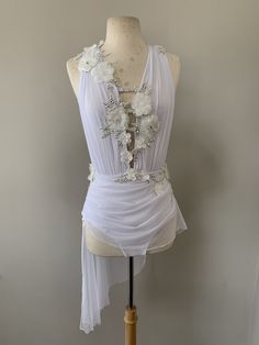 a mannequin wearing a white dress with flowers on it's neckline