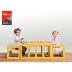 two children playing with toys on a yellow table