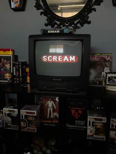 an old tv sitting on top of a shelf in front of a mirror with the word scream written on it