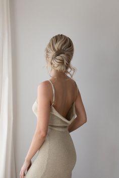 the back of a woman's dress, with her hands on her hips and one hand on her hip