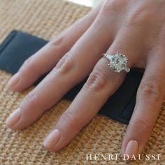 a close up of a person's hand with a diamond ring on top of it