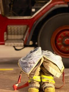 a firefighter's gear sits on the ground next to a fire truck