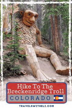 a large wooden statue sitting in the middle of a forest with text hike to the breckenridge troll colorado