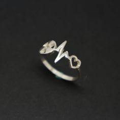 Silver Radiologic Technologist Heartbeat Ring is handmade with its own uniqueness. It can be bought as a gift for any occasion like birthday gift, wedding gift, travel gift, souvenir and etc. If you need rose gold plating or yellow gold plating, please contact us, we will advice you on the additional fees applicable. Base Material: Sterling Silver Size: 15mm X 9mm (Approximately) Ring Size: US 4 - US 14 (Please sellect your size) Metal Stamped: 925 Crafting Time: 7 - 10 working days Thickness: 1 Symbolic Heart Shaped Rings As Gifts, Personalized Silver Heart Ring As Gift, Personalized Silver Heart Ring For Gift, Personalized Silver Heart Ring Gift, Hypoallergenic Heart Ring For Valentine's Day Gift, Symbolic Heart Ring For Valentine's Day Gift, Symbolic Adjustable Heart Ring As Gift, Nickel Free Rings For Valentine's Day Gift, Unique Handmade Heart Ring For Gift