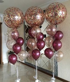 balloons are arranged on the floor in front of a mirror with confetti and sprinkles