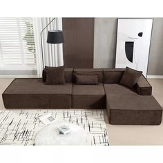 a living room with a large brown couch and white rugs on the floor in front of a window