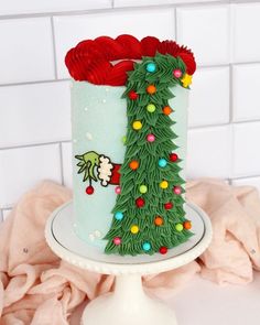 a decorated christmas tree cake sitting on top of a white plate