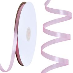 a roll of pink satin ribbon next to a white background