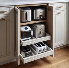 an open cabinet in a kitchen with toasters and other appliances