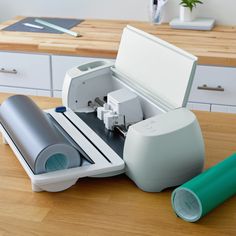 a machine that is sitting on top of a wooden table next to a roll of paper