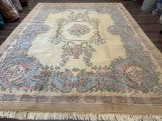 an antique rug is on display in a room with other furniture and decor items around it