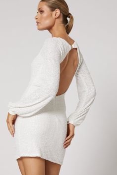 The perfect paradox, the Talei sequin dress by Winona is both poised and playful, with a sophisticated square neckline, elegant long sleeves, and a head-turning open back. A shimmering swath of all-over sequin embroidery and an ultra-mini hemline make her the perfect dress for any dance floor. White micro sequin on a mesh base Lined 100% Polyester Keyhole back Slight stretch fits true to size Glamorous Long Sleeve Dress With Back Zipper, Gala Long Sleeve Dress With Back Zipper, Long Sleeve Dresses With Back Zipper For Gala, Elegant Fitted Sequin Dress With Back Opening, Elegant Long Sleeve Backless Dress For Party, Elegant Sequin Dress With Back Zipper For Prom, Elegant Evening Sequin Dress With Back Zipper, Elegant Sequin Prom Dress With Back Zipper, Long Sleeve Gala Dress With Contrast Sequin