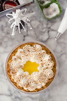 a pie sitting on top of a white table covered in frosting and toppings