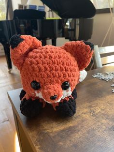 a crocheted stuffed animal sitting on top of a table next to a piano