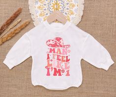 Man I Feel Like I'm One Baby Sweatshirt Romper, Western Cowgirl Bodysuit, Cowgirl 1St Groovy Romper, Newborn Outfit - Handmade     - Ships from USA     - Materials: 100% CPSIA Compliant and Ethically Made material   Light fabric (5.0 oz/yd² (170 g/m    Crafted with soft, breathable fabric, this romper ensures your baby stays comfortable through playtimes and nap times alike. Featuring charming designs suitable for all babies, our romper is as adorable as it is practical.     Quick Sizing Tip Cute Long Sleeve Onesie With Graphic Print, White Long Sleeve Onesie With Name Print, White Long Sleeve Onesie For First Birthday, Graphic Print Long Sleeve Top For First Birthday, White Long Sleeve Tops For First Birthday, Sweatshirt Romper, Nap Times, M Craft, Newborn Outfit