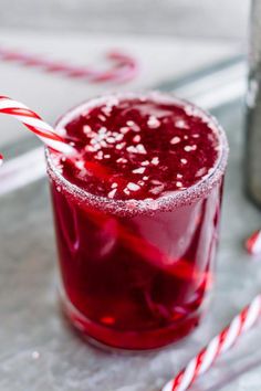 a red drink with a candy cane in it