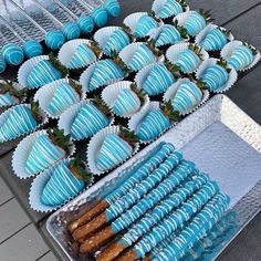 blue desserts and strawberries are on display for guests to eat at an outdoor event