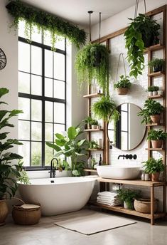 a white bath tub sitting next to a window filled with plants and potted plants