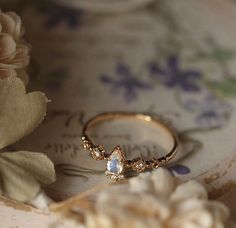 a close up of a ring with flowers in the background