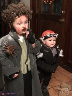 two children dressed up in halloween costumes and one is eating something out of his mouth