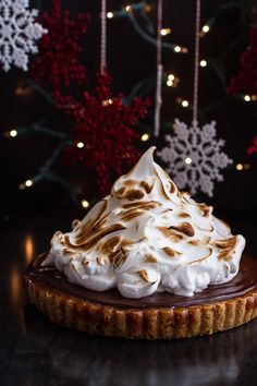 a chocolate tart topped with meringue and whipped cream