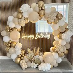 a happy birthday balloon arch with white and gold balloons in the shape of a wreath