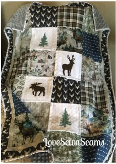 a quilted blanket with animals and trees on it