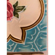 a blue and white tile with a rose on it