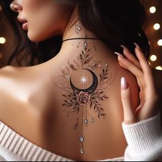 a woman with a tattoo on her back that has a crescent and flowers on it