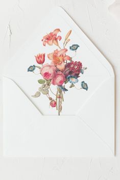 an envelope with flowers and butterflies on the inside is open to reveal a white envelope