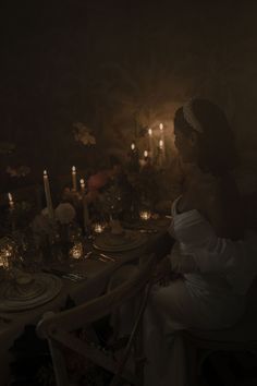 a woman sitting at a dinner table in the dark