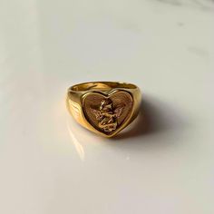 💛 Stay on trend with the new fall-inspired Gold Heart Angel Ring! This gold plated chunky signet ring combines vintage & y2k vibes. The cute heart shaped cupid ring is a non-tarnish, waterproof ring perfect for daily wear. Whether you're into Y2K jewelry or looking for a cute thick gold ring- it's a must-have! 🌟💖 #AngelRing #ChunkySignetRing #GoldHeartRing ♡ Sizes: US 6-10 ♡ Refunds/Returns: You have 14 days after receiving the product to get all of your money back, no questions asked. ♡ Ship Gold Signet Rings, Gold Rings Cheap, Chunky Signet Ring, Heart Shape Rings Gold, Vintage Gold Heart Cut Rings, Outfits With Gold Jewelry, Chunky Rings Gold, Big Gold Rings, Pinky Promise Rings