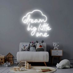 a room with a bed, teddy bears and a neon sign that says dream big little one