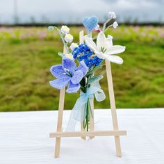 there is a vase with blue and white flowers in it on a table outside,