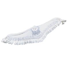 a white towel with an owl design on the bottom and fringes around it's edges