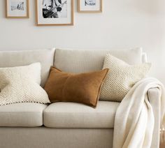 a couch with pillows and pictures on the wall