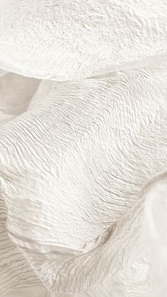 an abstract photo of white fabric with wavy lines in the middle and one line at the bottom