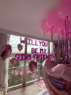 balloons and streamers fill the air in front of a window that reads, will you be my girlfriend?