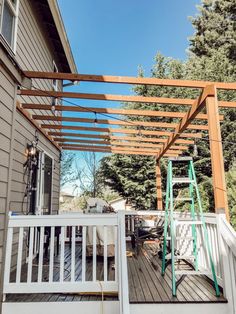 an outdoor deck with a pergolated roof and ladders on the side of it