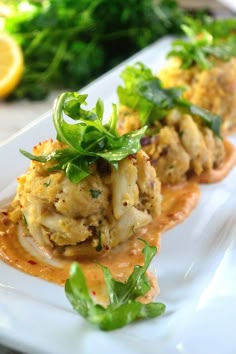 some food is on a white plate and garnished with green leafy greens