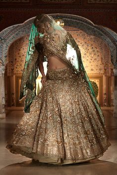 This champagne lehenga set features all over silver-gold zardozi embroidery on an organza base. The contrasting tissue organza dupatta is in an emerald tone with four sided border. From Seema Gujral’s Samode collectionDELIVERY TIMEPlease wait 8-12 weeks for your outfit to arrive.FABRIC DETAILSOrganzaProfessional cleaning only. Sage Green Bridal Lehenga, Champagne Lehenga, Sage Green Lehenga, Maroon Dupatta, Seema Gujral, White Lehenga, Latest Bridal Lehenga, Bridal Dupatta, Mehendi Outfits