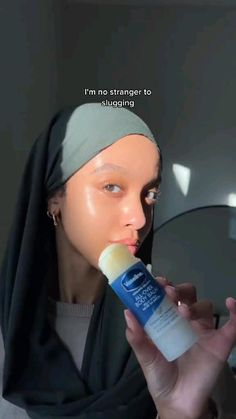 a mannequin wearing a headscarf and holding a tube of toothpaste