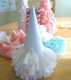 a party hat sitting on top of a table next to other paper trees and decorations