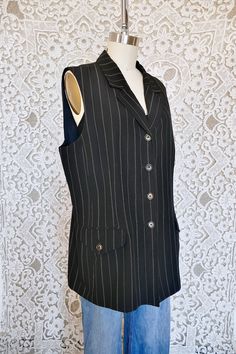 This lovely vest is made from an elegant crisp linen rayon blend. It features classic pinstripes, a long silhouette, pockets, and sharp collar. This piece could be dressed up or down. There is no size tag but it would best fit a size large, see measurements for details.  All measurements taken flat across. Measurements Bust: 21" Length: 29" Classic Fitted Pinstripe Vest, Tailored Pinstripe Sleeveless Vest, Pinstripe Cotton Button-up Blouse, Luxury Pinstripe Single-breasted Outerwear, Pinstripe Cotton Button-up Dress Shirt, Vest Outfits, Size Tag, Womens Vest, Linen Blend