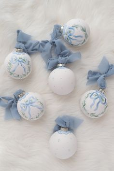 four white and blue ornaments with bows on them