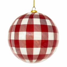 a red and white ornament hanging from a gold chain